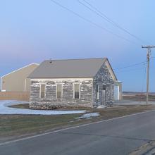 Unpainted schoolhouse during sunset