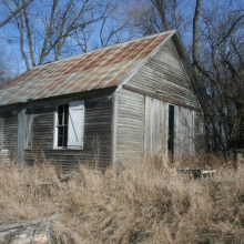 Photo of an unpainted schoolhouse