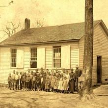 Yellowed class photo in front of the school